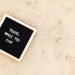 Letter board with 'Travel While You Can' message displayed on sandy beach scene, inspiring wanderlust.